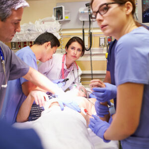 doctors surrounding hospital bed with patient