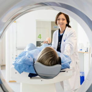 female doctor smiling at female patient in mri machine