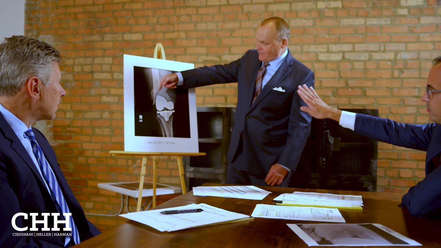 attorneys at table looking at surgical xray