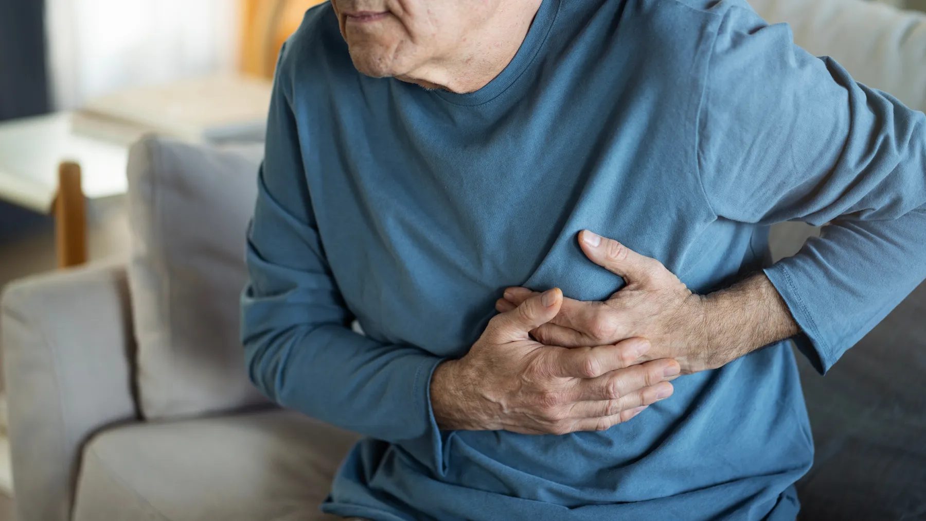 man experiencing a hearth attack and grabbing his chest